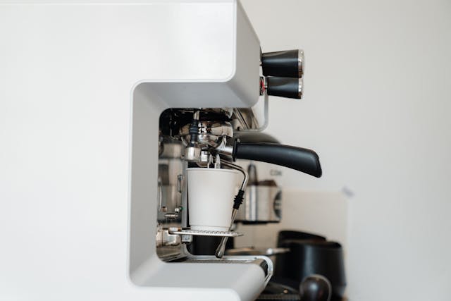 A selection of coffee makers, including a French press, espresso machine, and pour-over dripper, arranged on a kitchen counter.