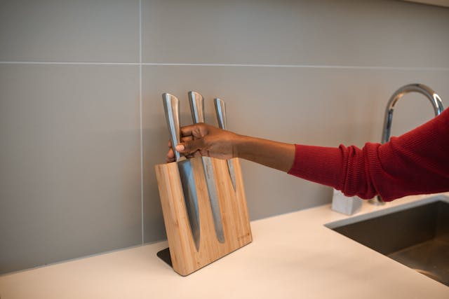 A modern kitchen with knives safely stored in a knife block and on a magnetic strip.